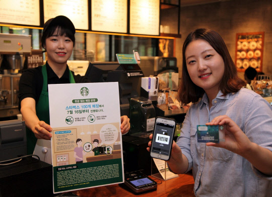 2일 스타벅스 매장에서 한 바리스타와 고객이 '현금 없는 매장'을 소개하고 있다. <스타벅스커피코리아 제공>